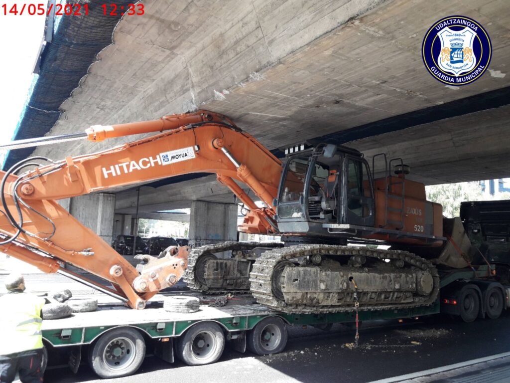 Antiguo puente La excavadora portada por un camión, atrapada bajo un puente de Ibaeta